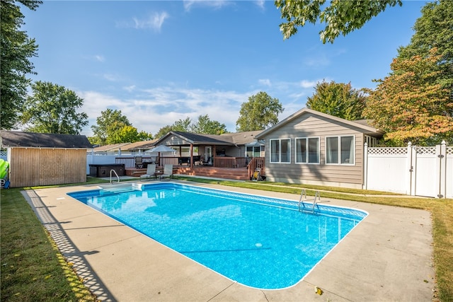 view of pool with a deck and a storage unit