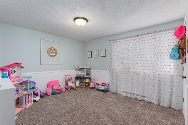 playroom with carpet and a textured ceiling