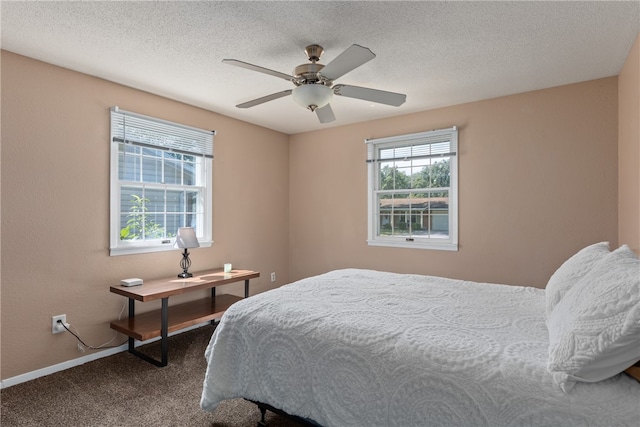 carpeted bedroom with ceiling fan and a textured ceiling