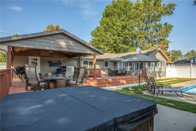 rear view of property with a swimming pool with hot tub