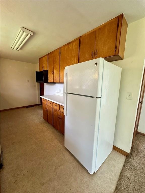 1321 Rudy Ave, Mattoon, IL 61938 - kitchen with freestanding refrigerator, light carpet, brown cabinets, and light countertops