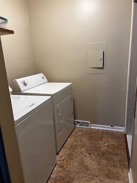 laundry room featuring washing machine and clothes dryer and electric panel