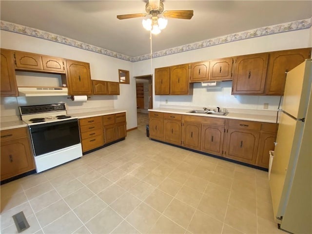 828 S Indiana St, Ashmore, IL 61912 - kitchen featuring white appliances, under cabinet range hood, brown cabinetry, light countertops, and ceiling fan