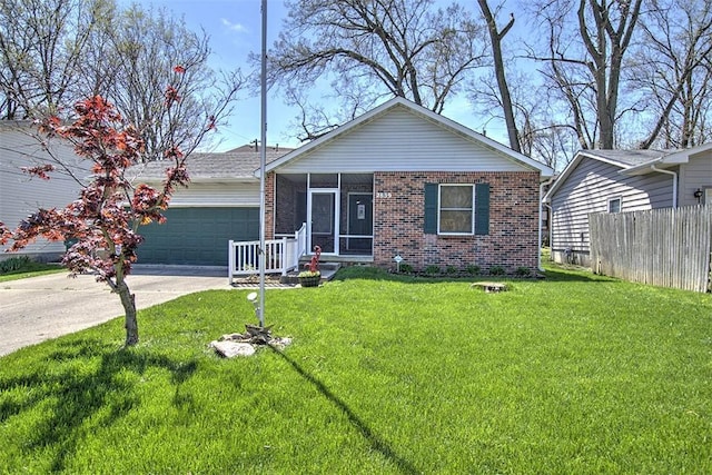 2839 E Wood St, Decatur, IL 62521 - view of front of house with fence, a front lawn, an attached garage, brick siding, and a sunroom