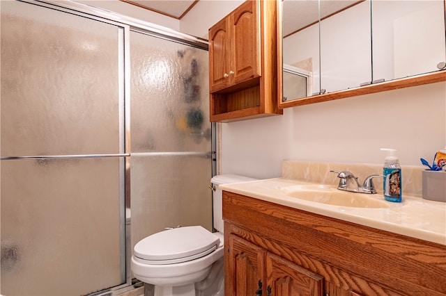 bathroom featuring vanity, an enclosed shower, and toilet