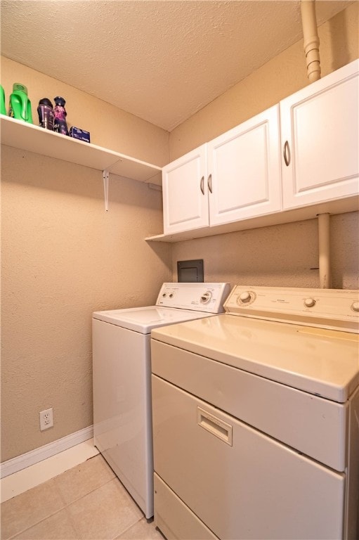 laundry room with cabinets, a textured ceiling, and washing machine and clothes dryer