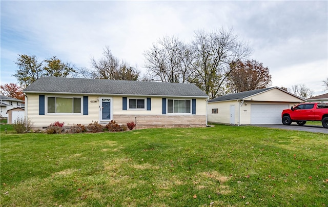 single story home featuring an outbuilding, a garage, and a front lawn