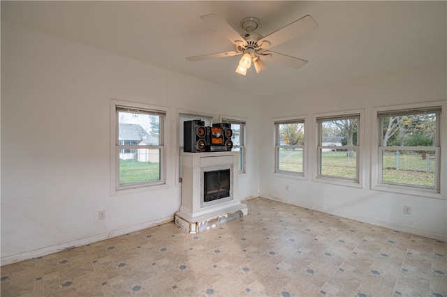 unfurnished living room featuring ceiling fan and a healthy amount of sunlight