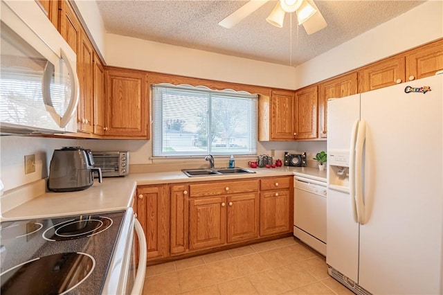 kitchen featuring a textured ceiling, white appliances, ceiling fan, sink, and light tile patterned flooring