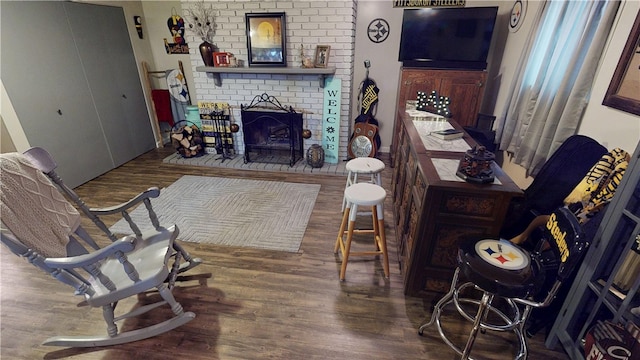 interior space with wood-type flooring and a brick fireplace