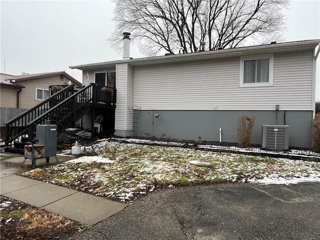 view of snow covered exterior featuring cooling unit