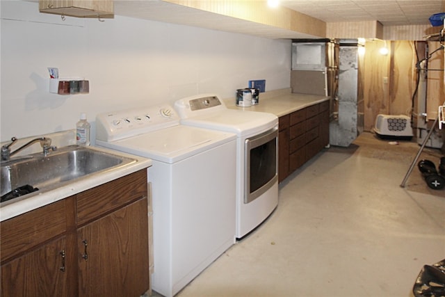 laundry room featuring separate washer and dryer, sink, and cabinets