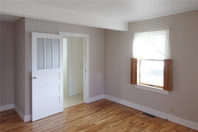 spare room with a healthy amount of sunlight and light hardwood / wood-style floors