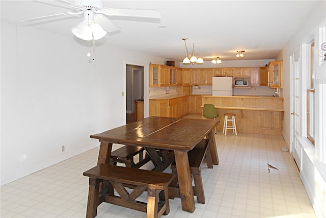 dining room featuring ceiling fan with notable chandelier