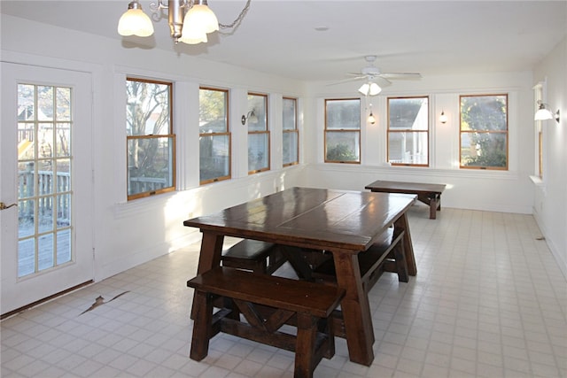 dining space with ceiling fan with notable chandelier