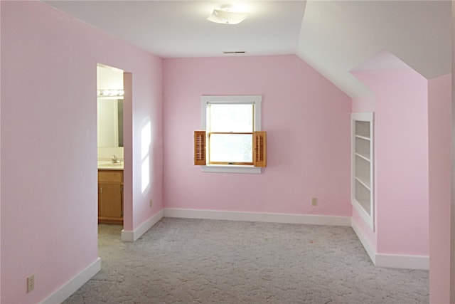 bonus room with light colored carpet, lofted ceiling, and sink