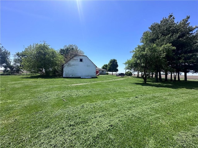 view of green lawn featuring a barn