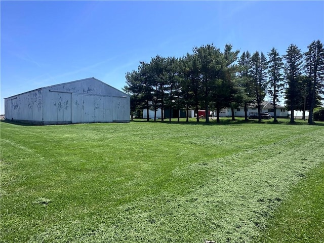 view of green lawn with an outbuilding and an outdoor structure