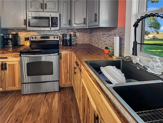 kitchen featuring appliances with stainless steel finishes, a sink, plenty of natural light, and decorative backsplash