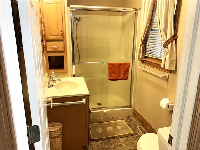 bathroom featuring vanity, toilet, and an enclosed shower