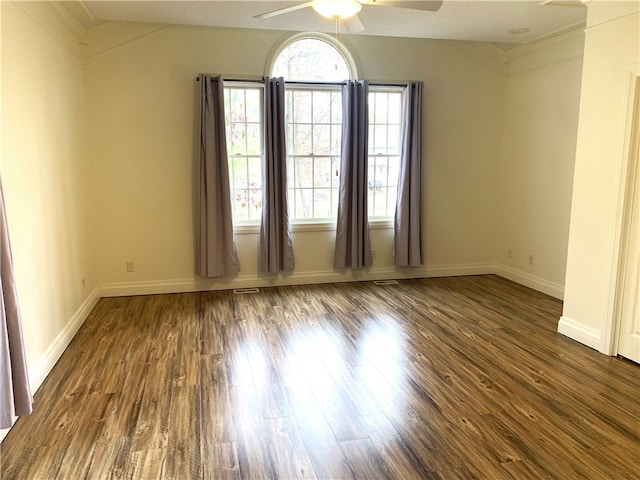 unfurnished room featuring dark wood-type flooring and ceiling fan