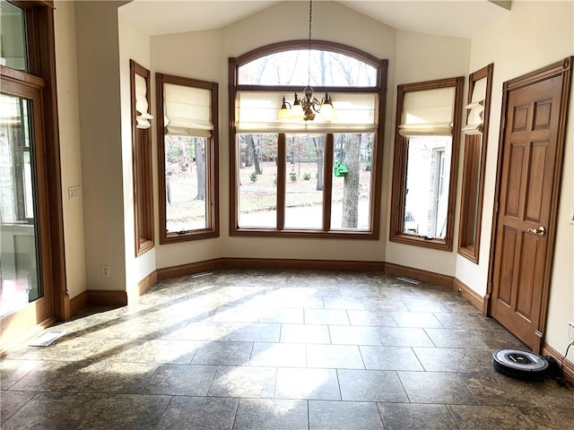 spare room with a notable chandelier and vaulted ceiling