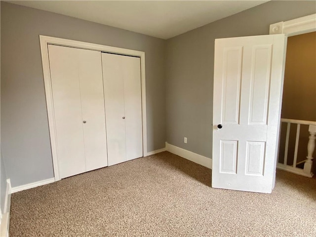 unfurnished bedroom featuring a closet, baseboards, and carpet floors