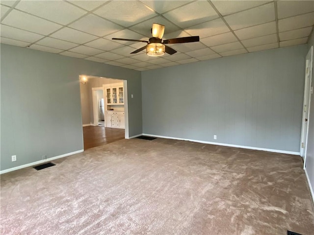 unfurnished room featuring carpet, a ceiling fan, visible vents, and a drop ceiling