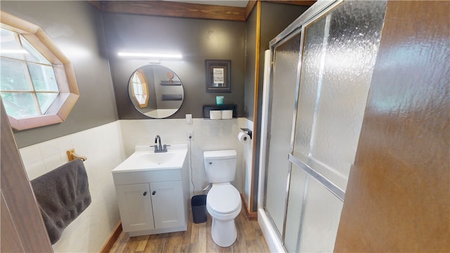 1006 Chicago Ave, Danville, IL 61832 - bathroom featuring toilet, vanity, wood finished floors, a shower stall, and tile walls