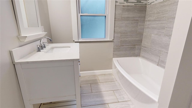 full bath with baseboards, a washtub, a shower, and vanity