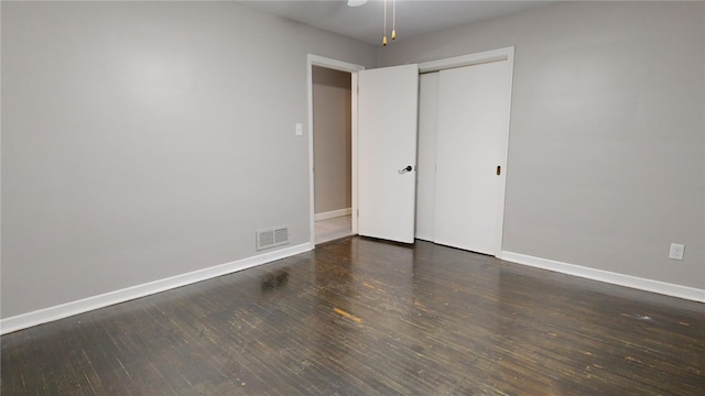 unfurnished bedroom featuring wood finished floors, visible vents, and baseboards