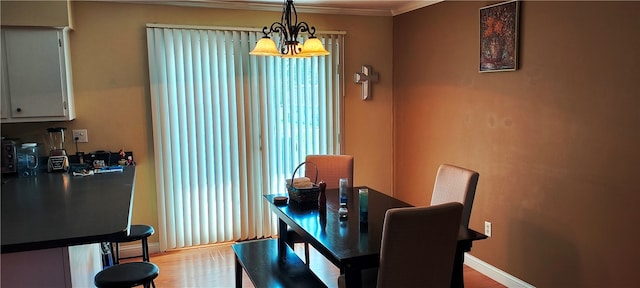 dining room with a notable chandelier, light hardwood / wood-style floors, and ornamental molding