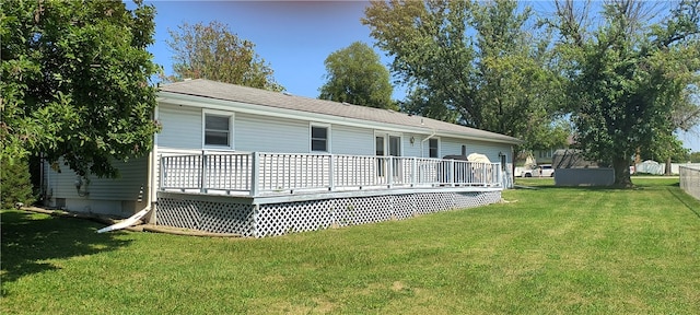 back of house featuring a shed, a deck, and a yard