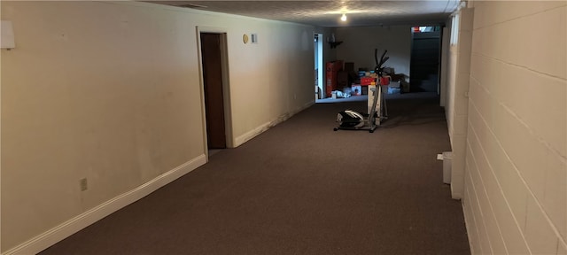 hall featuring carpet flooring and a textured ceiling