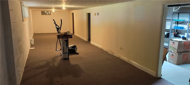 exercise room featuring dark colored carpet and a textured ceiling