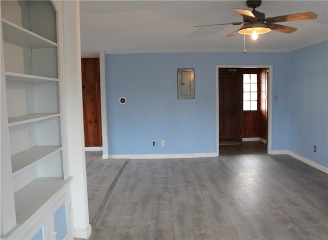 spare room featuring ceiling fan, wood-type flooring, ornamental molding, and electric panel