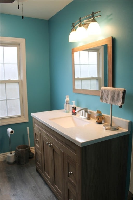 bathroom with ceiling fan, vanity, and wood-type flooring