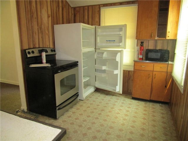 1729 N 20th St, Springfield, IL 62702 - kitchen with stainless steel electric range, black microwave, light flooring, wood walls, and brown cabinetry