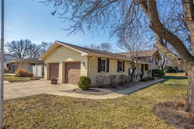 view of front of home with an attached garage, driveway, a front lawn, and brick siding