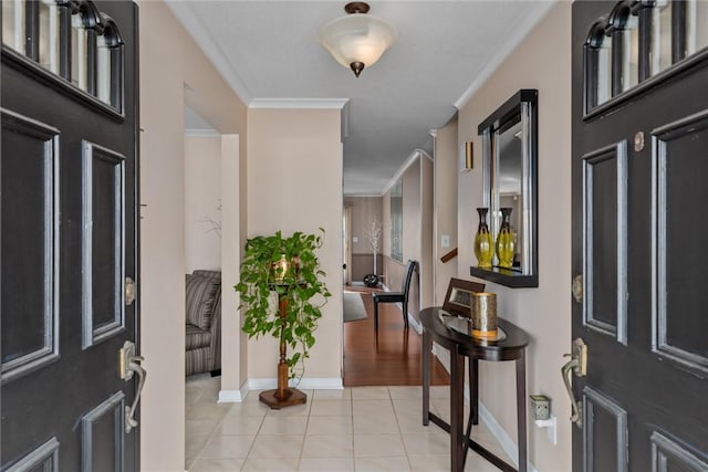 foyer entrance with baseboards, light tile patterned flooring, and crown molding