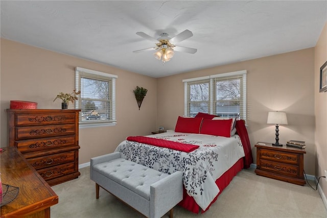 carpeted bedroom with ceiling fan and baseboards