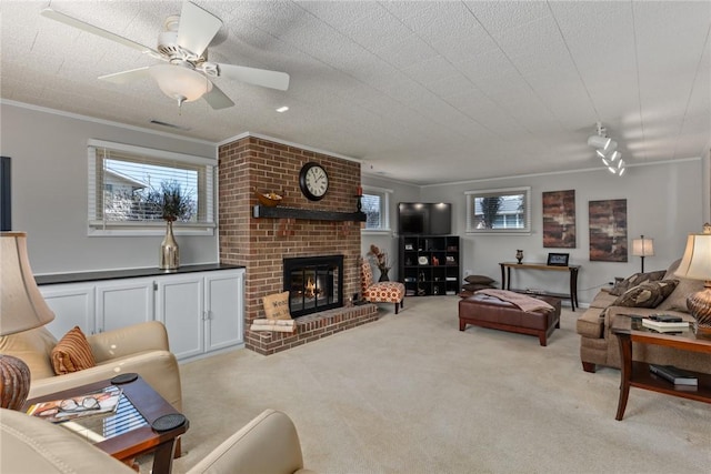 living room with a healthy amount of sunlight, light carpet, crown molding, and a fireplace