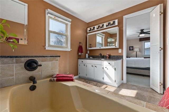 bathroom featuring a garden tub, connected bathroom, and vanity