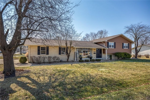 tri-level home featuring brick siding and a front yard