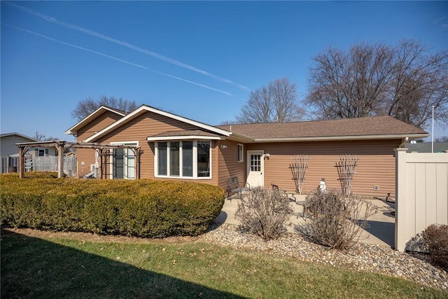 view of front of house featuring a front lawn, a patio area, and fence