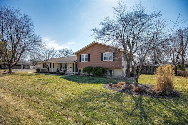 split level home featuring fence and a front yard