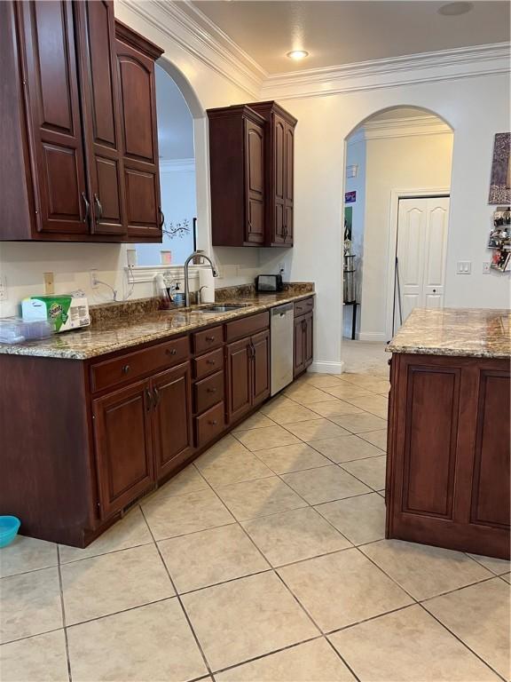 kitchen featuring dishwasher, ornamental molding, sink, and dark stone counters