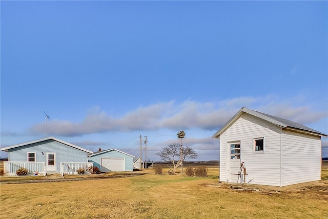 view of side of property featuring an outbuilding and a lawn