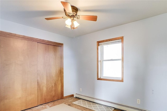 unfurnished bedroom featuring ceiling fan, baseboard heating, and a closet