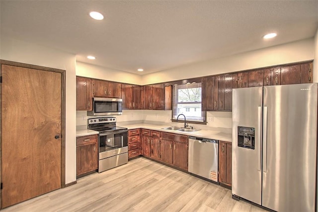 113 White Pines Cir, Decatur, IL 62521 - kitchen featuring appliances with stainless steel finishes, a sink, light countertops, light wood-style floors, and recessed lighting